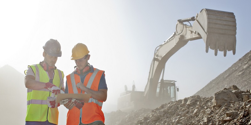 Workers reading blueprints in quarry